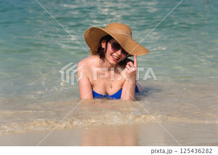 A moment of summer happiness, a woman basks in the gentle waves of the sea 125436282