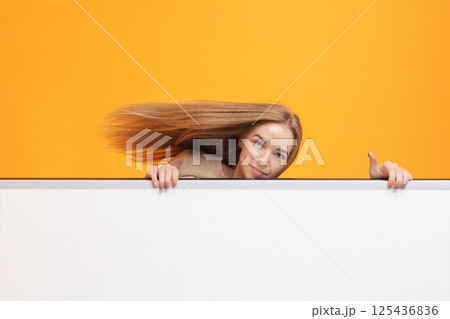 Woman Peeking Over White Panel Woman Peeking Over White Panel 125436836