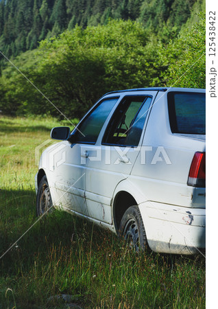 White abandoned car in forest 125438422