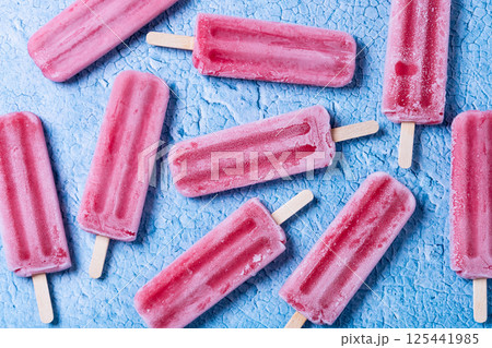 Red strawberry popsicles on blue background. 125441985