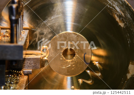 Close up scene the lathe machine finish cut the brass material. Close up scene the lathe machine finish cut the brass material. 125442511