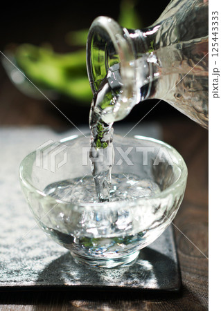 注がれる日本酒と枝豆 125443333