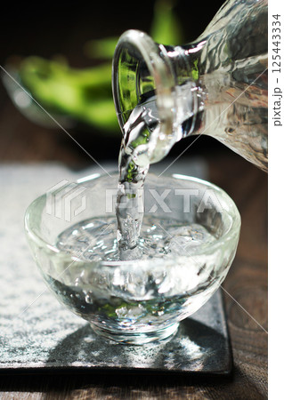 注がれる日本酒と枝豆 125443334