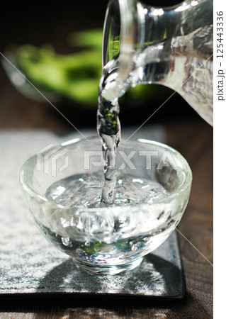 注がれる日本酒と枝豆 125443336