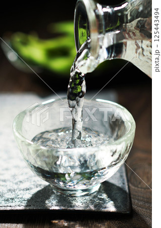 注がれる日本酒と枝豆 125443494