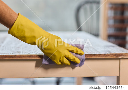 Effectively Cleaning A Table Surface With A Sponge For A Neat And Tidy Appearance Effectively Cleaning A Table Surface With A Sponge For A Neat And Tidy Appearance 125443654