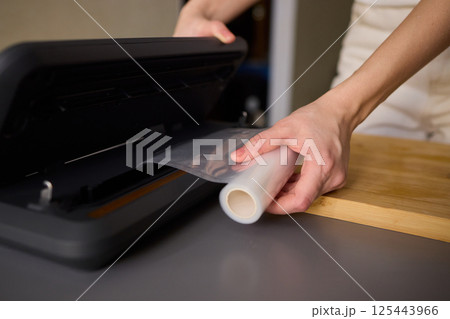 Hands Skillfully Preparing Vacuum Sealing for Food Preservation and Storage Purposes Hands Skillfully Preparing Vacuum Sealing for Food Preservation and Storage Purposes 125443966