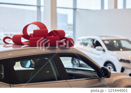 The new car is wrapped in a red bow. Beautiful gift concept. 125444001