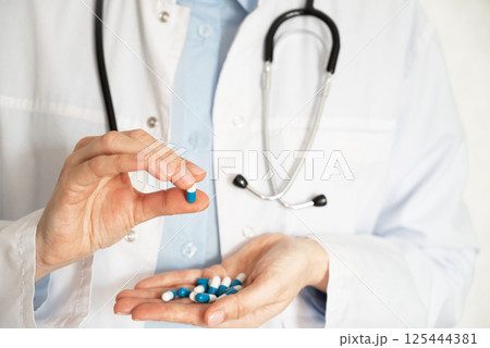 Doctor discusses medication options while seated at a desk in a clinical office setting Doctor discusses medication options while seated at a desk in a clinical office setting 125444381