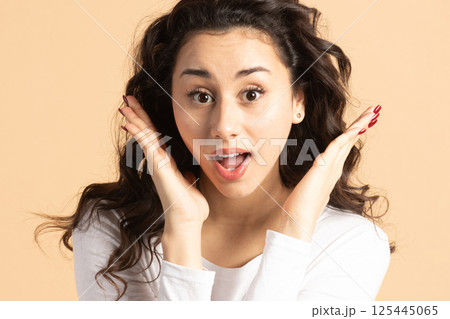 Surprised woman portrait with raised hand palms and open mouth 125445065