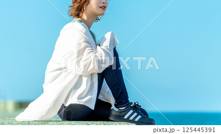 夏の海辺にたたずむ笑顔の女性 夏の海辺にたたずむ笑顔の女性 125445391