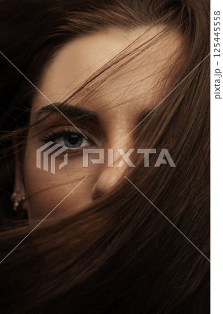 Beautiful woman with blue eyes cover her face with hair Beautiful woman with blue eyes cover her face with hair 125445558