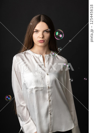 Beautiful woman with soap bubbles studio portrait Beautiful woman with soap bubbles studio portrait 125445618