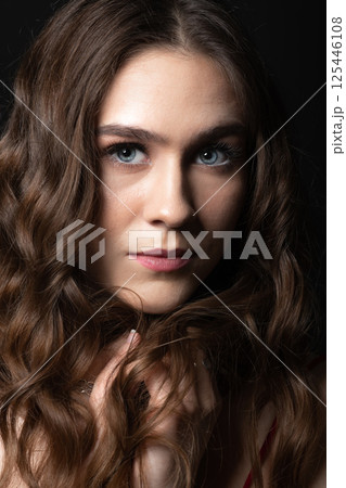 Beautiful brunette woman with long wavy hair studio portrait Beautiful brunette woman with long wavy hair studio portrait 125446108