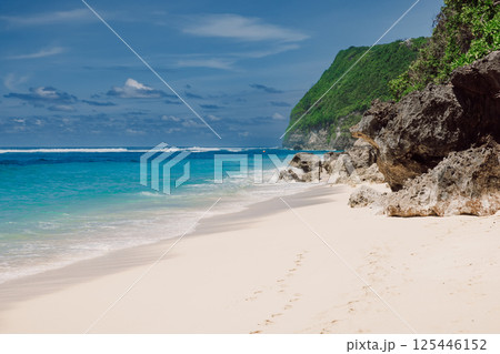 Tropical beach with ocean and cliff rocks. Holidays in luxury paradise island Tropical beach with ocean and cliff rocks. Holidays in luxury paradise island 125446152