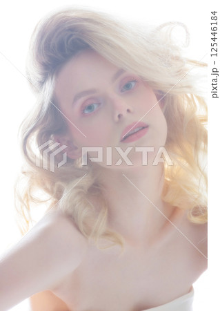 Beautiful woman with big wavy hair studio portrait in bright background 125446184