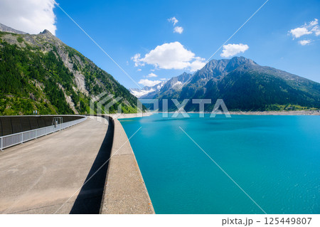 Azure lake, dam and high mountain range in Austria. Mountain landscapes during summer. Azure lake, dam and high mountain range in Austria. Mountain landscapes during summer. 125449807