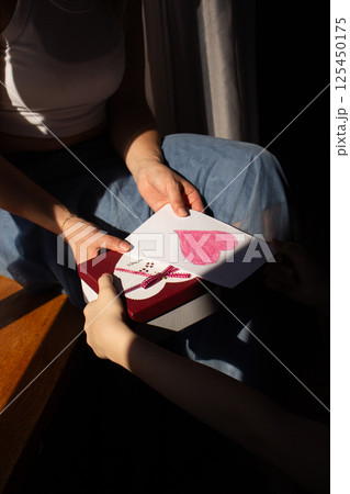 Excited Caucasian mom receiving handmade gift for mother's day from her teenage daughter. Happy family celebrating together at home. Close up. Excited Caucasian mom receiving handmade gift for mother's day from her teenage daughter. Happy family celebrating together at home. Close up. 125450175
