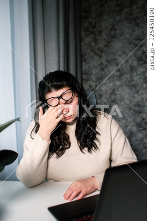 Tired Caucasian woman feeling stressed from work problems. Irritation burnout. Rubbing eyes. Dealing with work deadlines. Have not enough sleep 125450190