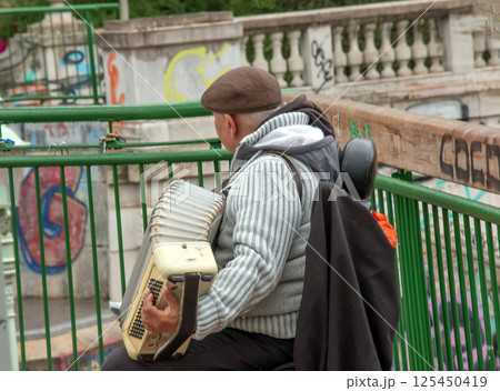 Vienna, Austria - 05.13.2023: A street musician plays the button accordion. Vienna, Austria - 05.13.2023: A street musician plays the button accordion. 125450419