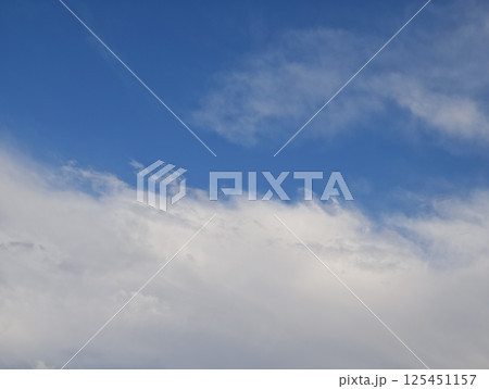White clouds gently drifting across a vibrant blue sky White clouds gently drifting across a vibrant blue sky 125451157