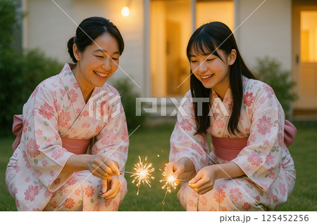 自宅の庭で線香花火を楽しむ浴衣姿の日本人親子 自宅の庭で線香花火を楽しむ浴衣姿の日本人親子 125452256