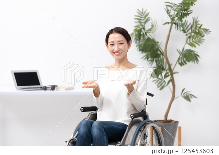 車椅子の女性　在宅ワーク　手かざし 125453603