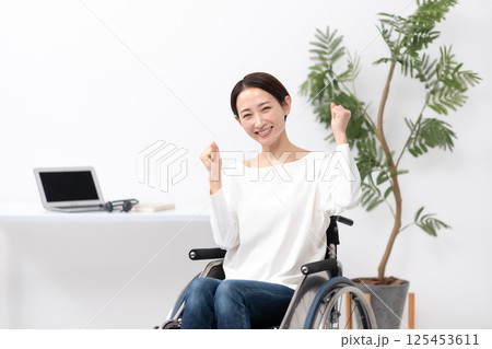 車椅子の女性　在宅ワーク　ガッツポーズ 125453611