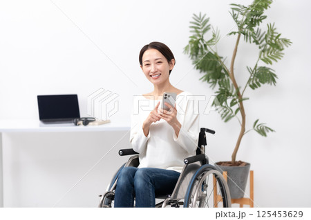 車椅子の女性　在宅ワーク　スマホ 125453629