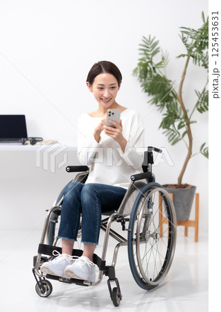 車椅子の女性 在宅ワーク スマホ 車椅子の女性 在宅ワーク スマホ 125453631
