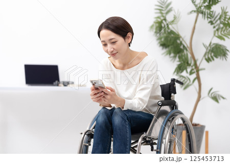 車椅子に女性　在宅ワーク　スマホ 125453713