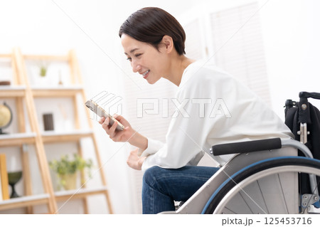 車椅子に女性　スマホ 125453716