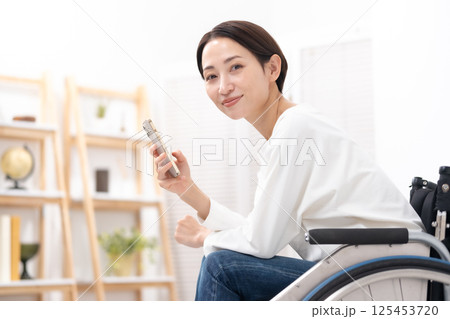 車椅子に女性 スマホ 車椅子に女性 スマホ 125453720