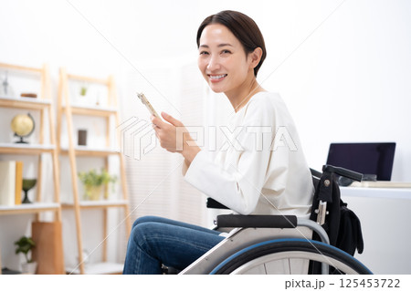 車椅子に女性　スマホ 125453722