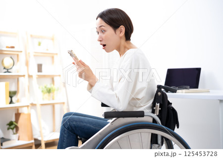 車椅子に女性　スマホ　悩む 125453728