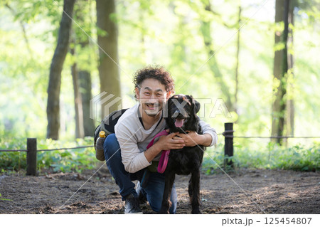 犬を散歩する男性 ドッグトレーナーや飼い主などの仲良しなイメージ カメラ目線 犬を散歩する男性 ドッグトレーナーや飼い主などの仲良しなイメージ カメラ目線 125454807