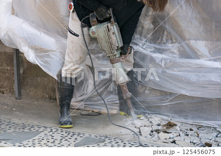 電動ハンマ(ジャンクハンマー）でコンクリートを割る土木作用員 125456075