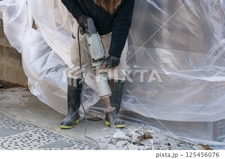 電動ハンマ(ジャンクハンマー）でコンクリートを割る土木作用員 125456076