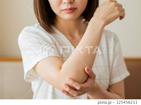 右腕のひじに痛みを感じている女性 右腕のひじに痛みを感じている女性 125456211
