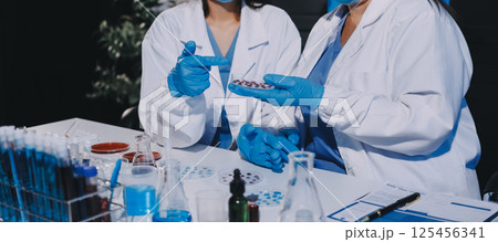 Researcher using a professional microscope Researcher using a professional microscope 125456341