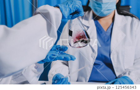 Researcher using a professional microscope 125456343