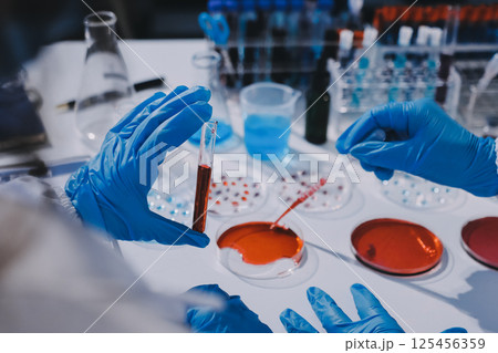Researcher using a professional microscope 125456359