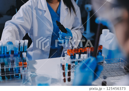 Researcher using a professional microscope Researcher using a professional microscope 125456373