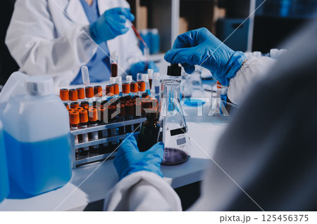 Researcher using a professional microscope 125456375
