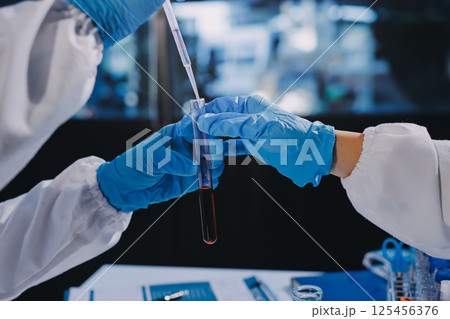 Researcher using a professional microscope Researcher using a professional microscope 125456376