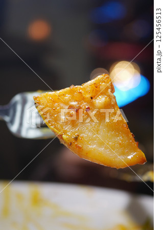 Delicious golden potato slice on a fork ready to enjoy 125456513