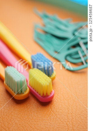 Colorful toothbrushes and dental floss tools on a bright surface 125456687