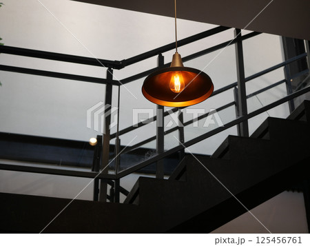 Modern lighting fixture illuminating a stylish staircase indoors Modern lighting fixture illuminating a stylish staircase indoors 125456761