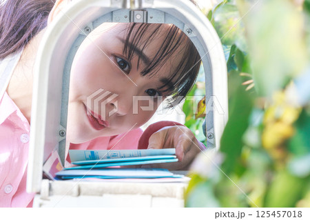 郵便物を取り出す女性 郵便物を取り出す女性 125457018