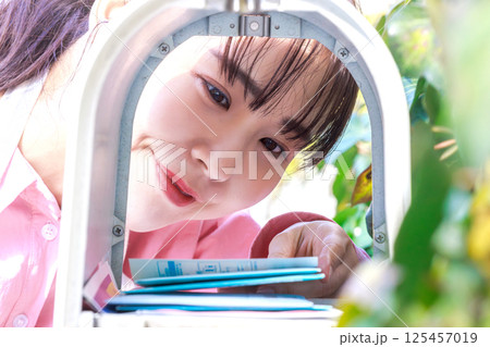 郵便物を取り出す女性 125457019